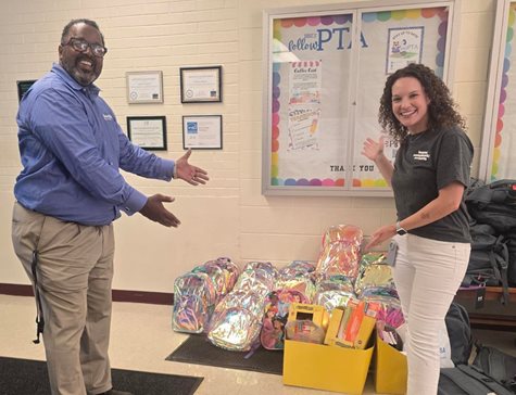 Man and woman showing backpacks and school supplies